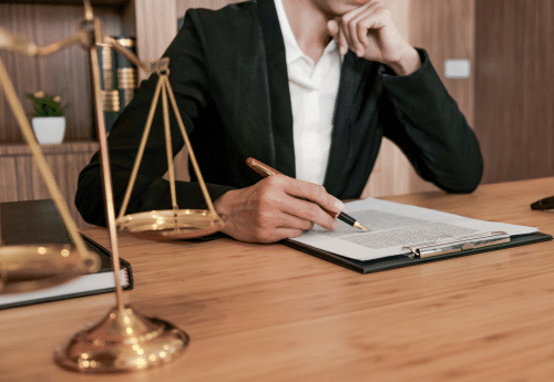 Conseiller juridique analysant un contrat dans un bureau, avec balance de la justice en premier plan – accompagnement des exploitants agricoles sur les aspects juridiques et réglementaires.