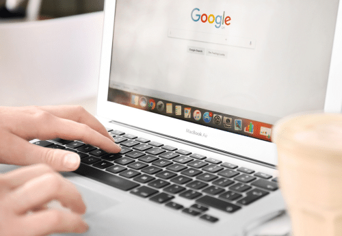 Utilisateur saisissant une recherche Google sur un ordinateur portable – création et optimisation de la fiche Google My Business pour améliorer la visibilité locale des commerçants et artisans.