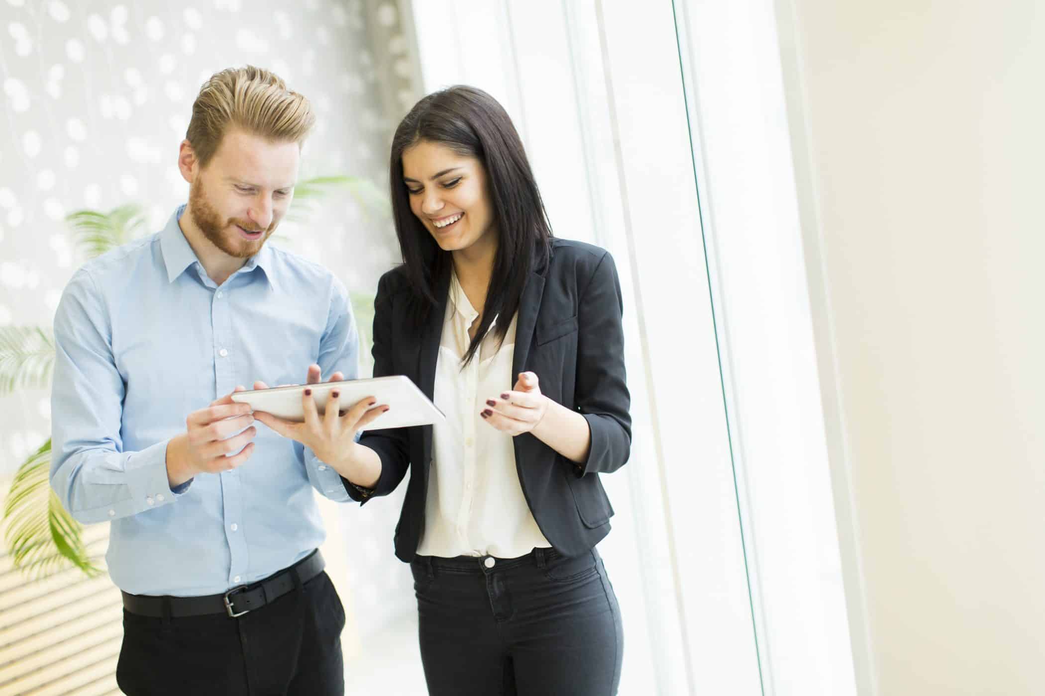 Deux experts sur une tablette en train d'évoquer la stratgié de leur consolidation client.