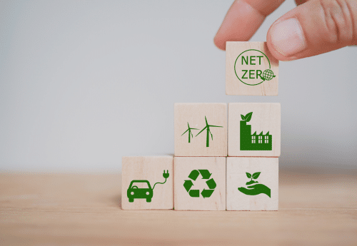 Main qui empile des dès représentant chacun un pilier de la RSE.