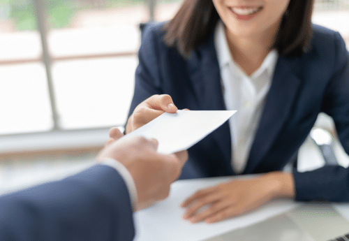 Remise d’un bulletin de paie dans un réseau de franchise, symbolisant la gestion des ressources humaines, la conformité sociale et l’harmonisation des pratiques de paie entre franchisés.

