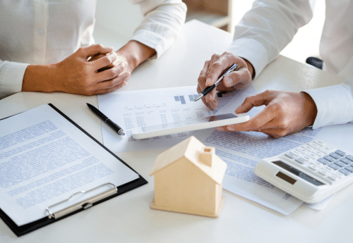 Un  conseiller en comptabilité discute et calcule une TVA immobilière avec son client, un agent immobilier.