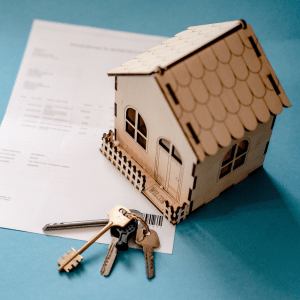 Maison miniature et clés posées sur un document, illustrant l’investissement locatif et les nouvelles règles de défiscalisation immobilière issues de la loi de finances 2026.