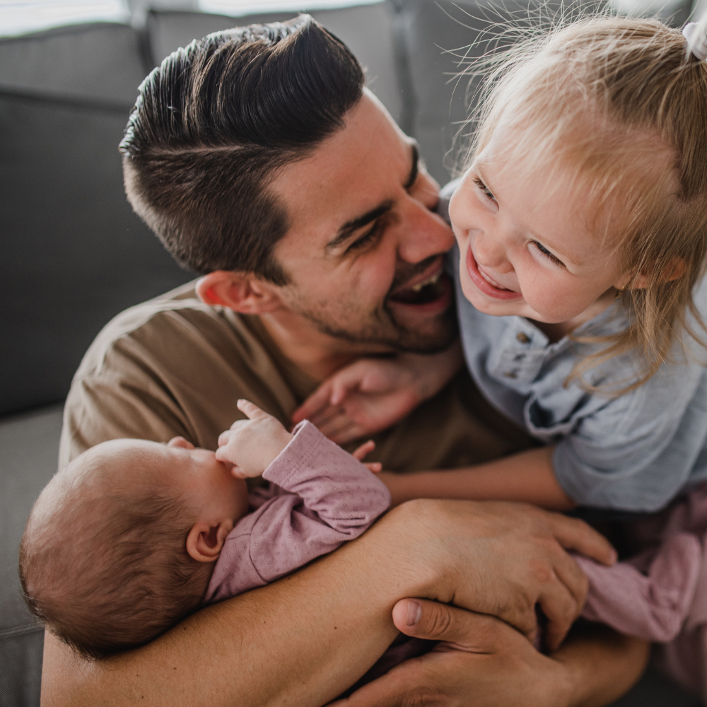 Un père avec ses enfants pendant son congé supplémentaire de naissance.